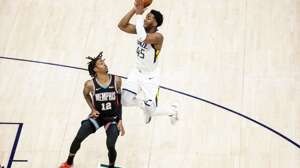 Utah Jazz guard Donovan Mitchell (45) shoots over Memphis Grizzlies guard Ja Morant (12) during the game at Vivint Smart Home Arena in Salt Lake City on Friday, March 26, 2021.