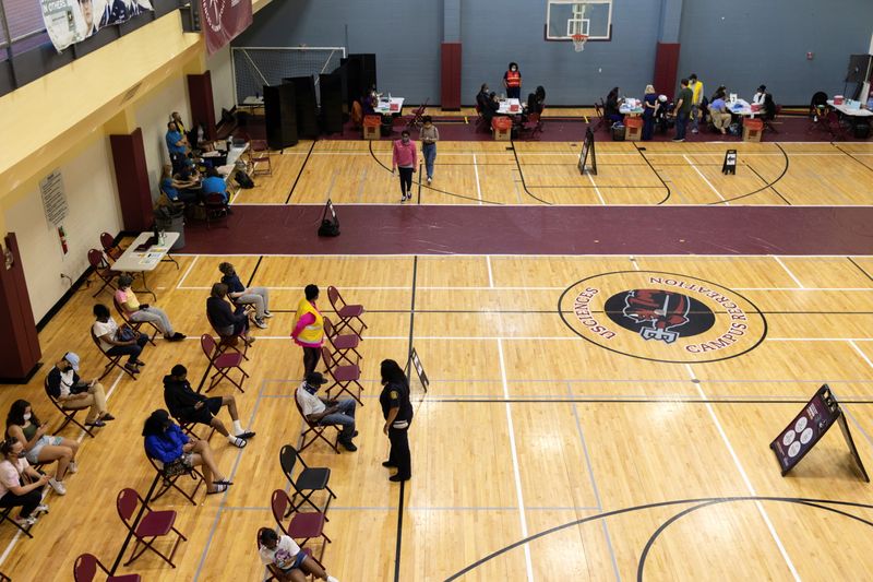 FILE PHOTO: People wait after receiving a coronavirus disease (COVID-19) vaccine at a clinic run by the Philadelphia Department of Public Health in partnership with the Black Doctors COVID-19 Consortium to encourage all eligible teenagers to get vaccinated in Philadelphia, Pennsylvania, U.S., May 18, 2021. REUTERS/Hannah Beier