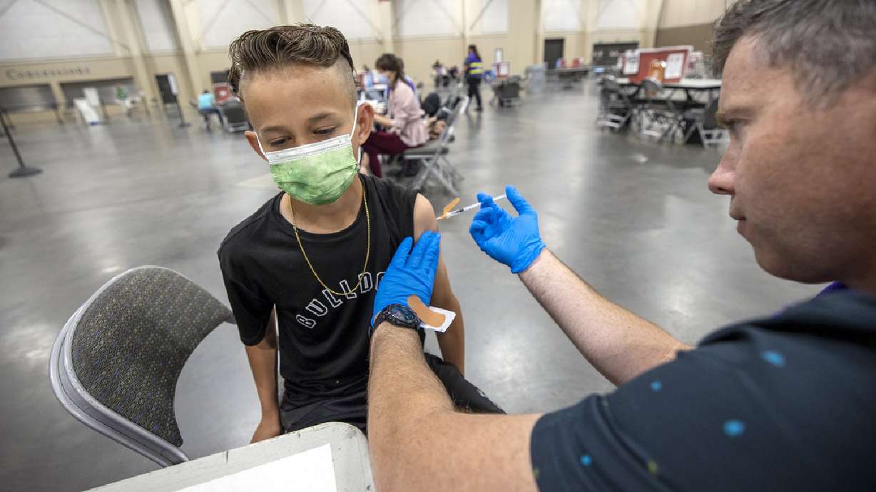 Carson Atkinson, 12, gets a COVID-19 vaccination at the Mountain America Exposition Center in Sandy on Tuesday, May 18, 2021