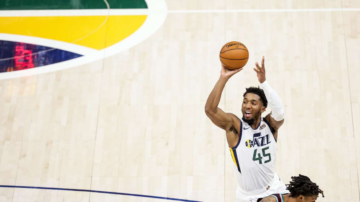 Utah Jazz guard Donovan Mitchell (45) shoots over Memphis Grizzlies guard Ja Morant (12) during the game at Vivint Smart Home Arena in Salt Lake City on Friday, March 26, 2021.