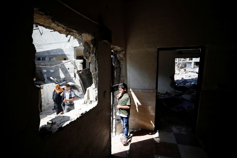 A Palestinian boy stands inside a house which was damaged by Israeli air strikes during the Israel-Hamas fighting in Gaza May 23, 2021. REUTERS/Mohammed Salem