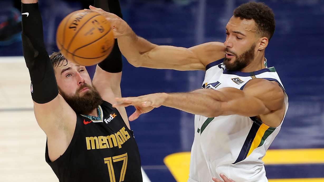 Utah Jazz center Rudy Gobert (27) passes the ball around Memphis Grizzlies center Jonas Valanciunas (17) as the Utah Jazz and the Memphis Grizzlies play in game one of their NBA playoff series at Vivint Arena in Salt Lake City on Sunday, May 23, 2021.