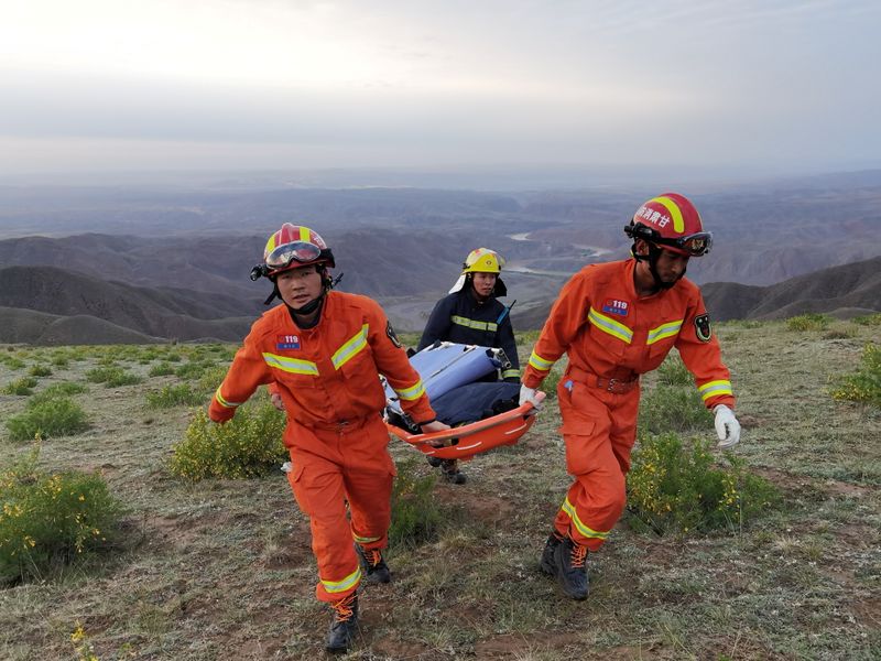 FILE PHOTO: Rescue workers carry a stretcher as they work at the site where extreme cold weather killed participants of an 100-km ultramarathon race in Baiyin, Gansu province, China May 22, 2021.  cnsphoto via REUTERS