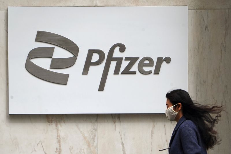 FILE PHOTO: A person walks past a Pfizer logo amid the coronavirus disease (COVID-19) pandemic in the Manhattan borough of New York City, New York, U.S., April 1, 2021. REUTERS/Carlo Allegri/File Photo