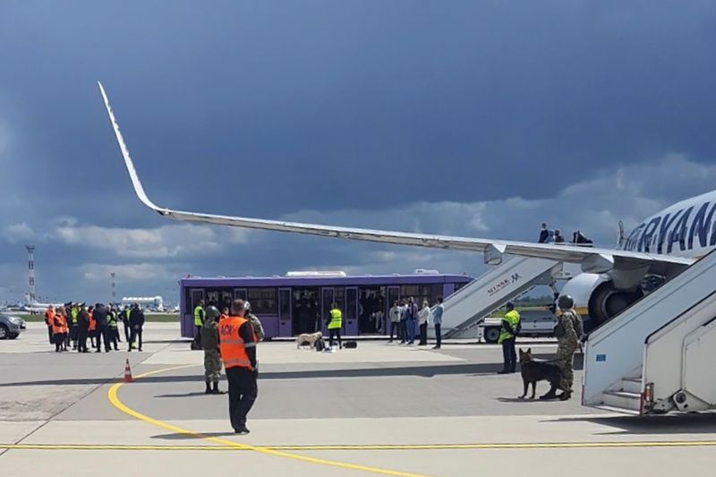 Airport personnel and security forces are seen on the tarmac in front of a Ryanair flight which was forced to land in Minsk, Belarus, May 23, 2021.