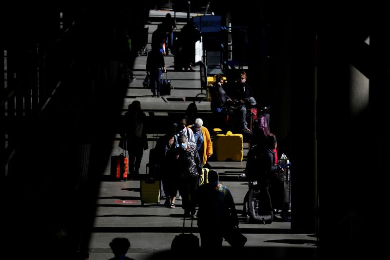 FILE PHOTO: Travelers walk through a pick-up area in the arrivals section at Seattle-Tacoma International Airport in SeaTac, Washington, U.S. April 12, 2021.  REUTERS/Lindsey Wasson