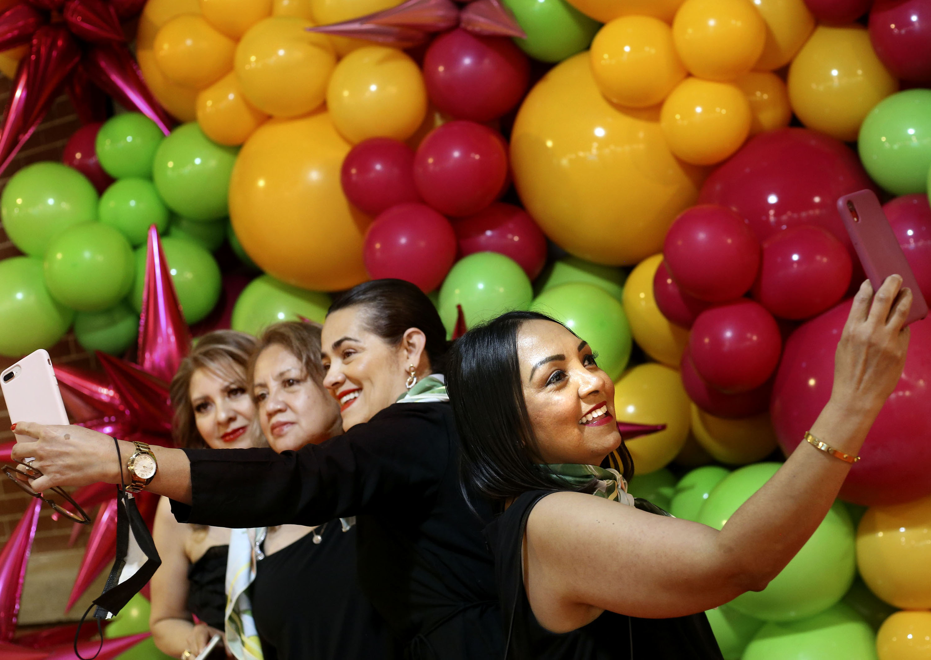 Cancer survivor Nora Serrano, right, Sara Carbajal-Salisbury, health program director for Alliance Community Services, and cancer survivors Beneranda Marquez and Ana Dant take photos during the Utah Latin Runway & Trunkshow at The Gateway in Salt Lake City on Saturday, May 22, 2021.