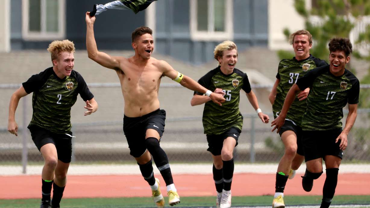 Wasatch's Edgar Garcia is swarmed by teammates after he scored on a penalty kick in overtime in the 5A soccer semifinals at Herriman against Maple Mountain on Tuesday, May 25, 2021.