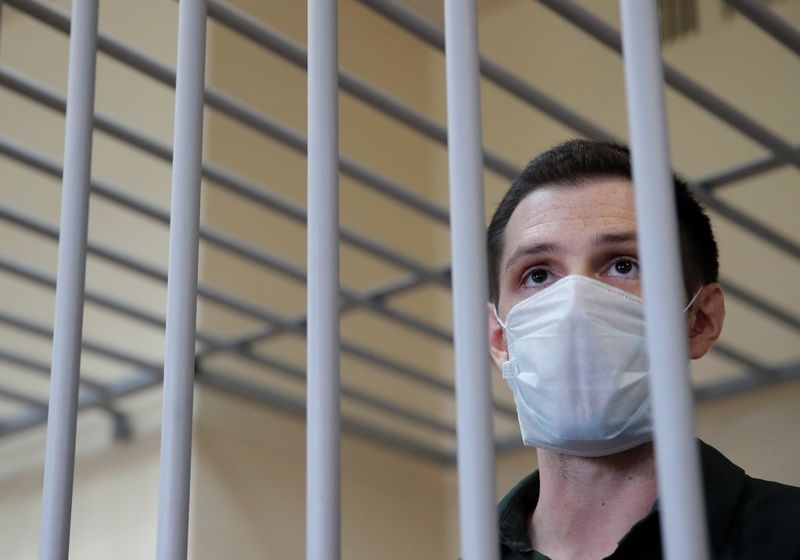 FILE PHOTO: Former U.S. Marine Trevor Reed, who was detained in 2019 and accused of assaulting police officers, stands inside a defendants' cage during a court hearing in Moscow, Russia July 30, 2020. REUTERS/Maxim Shemetov