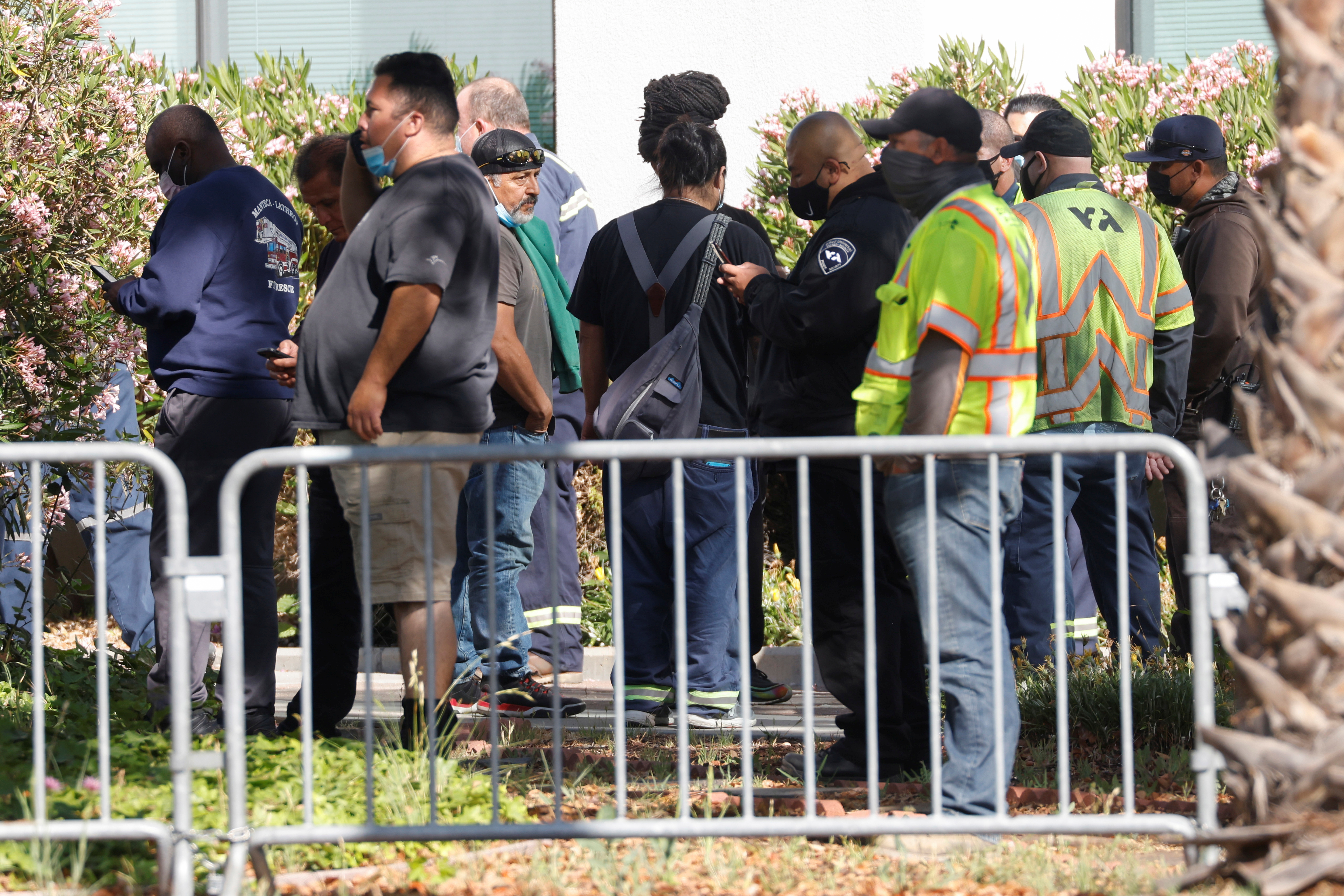Valley Transportation Authority workers wait outside the Santa Clara Sheriff's offices as police secure the scene of a mass shooting at a rail yard run by the Santa Clara Valley Transportation Authority in San Jose, California, on May 26, 2021.