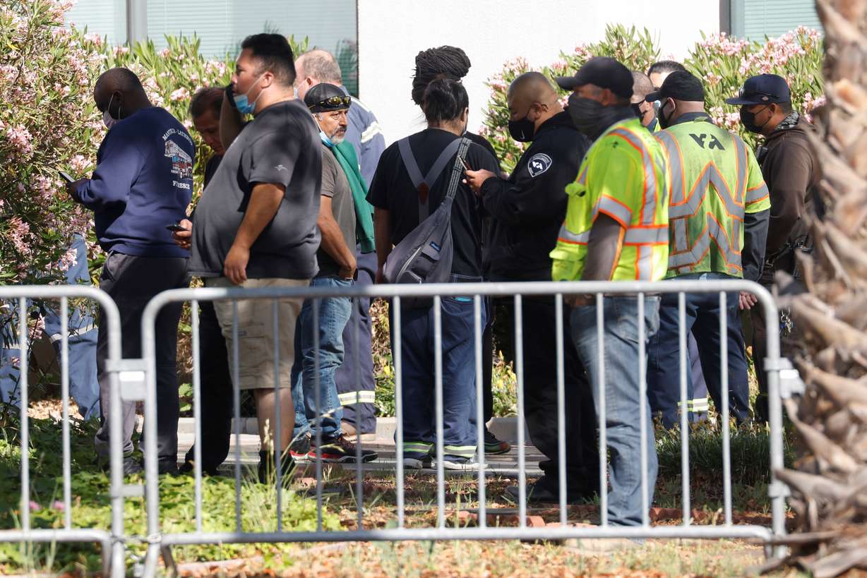 Valley Transportation Authority workers wait outside the Santa Clara Sheriff's offices as police secure the scene of a mass shooting at a rail yard run by the Santa Clara Valley Transportation Authority in San Jose, California, on May 26, 2021.
