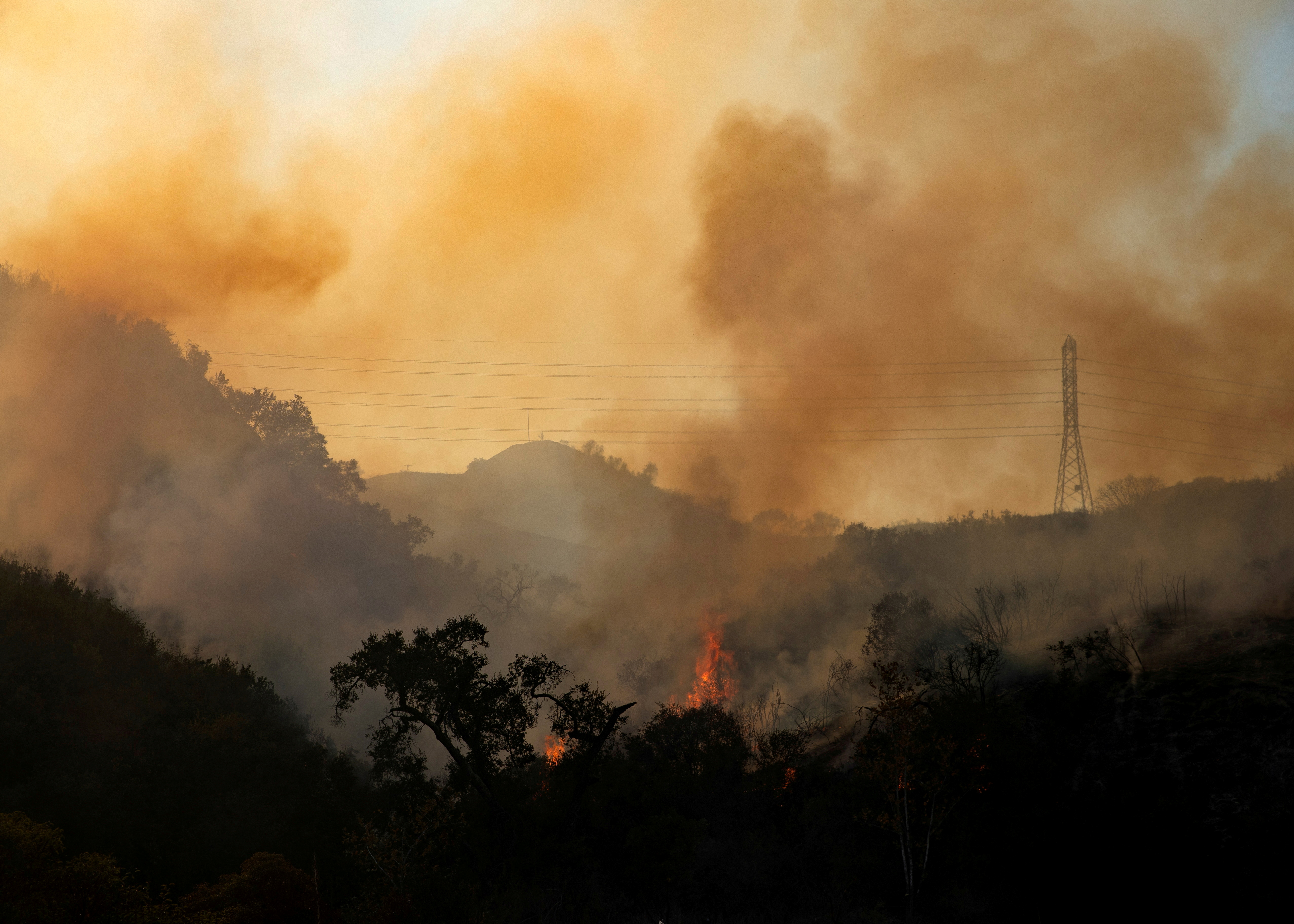 FILE PHOTO: The Bond Fire wildfire burns next to electrical power lines near Modjeska Canyon, California, U.S., December 3, 2020