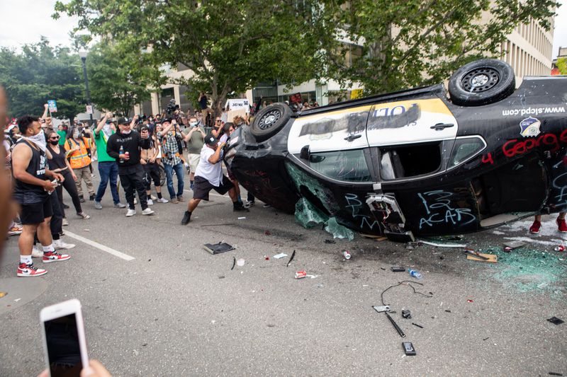 People take photos of a damaged police car May 30, 2020
in Salt Lake City as they protest the death of George Floyd at the
hands of a police officer in Minnesota.