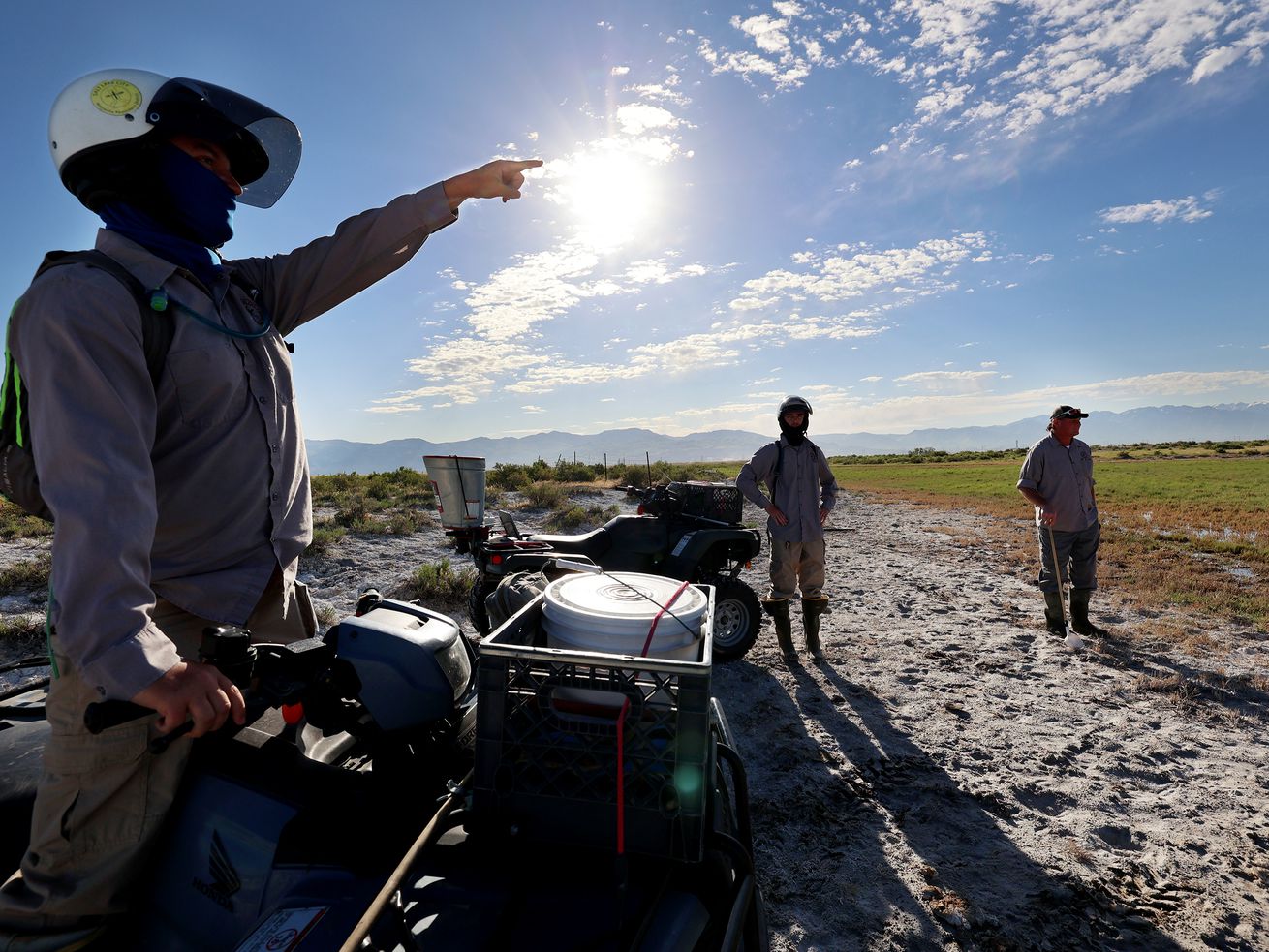 Salt Lake Mosquito Abatement District’s Nick Hill,
left, and Jonah Willis talk with operations supervisor Jason
Hardman as they determine where they need to spread mosquito
insecticide in the wetlands north and west of Salt Lake City on
Friday, May 28, 2021.