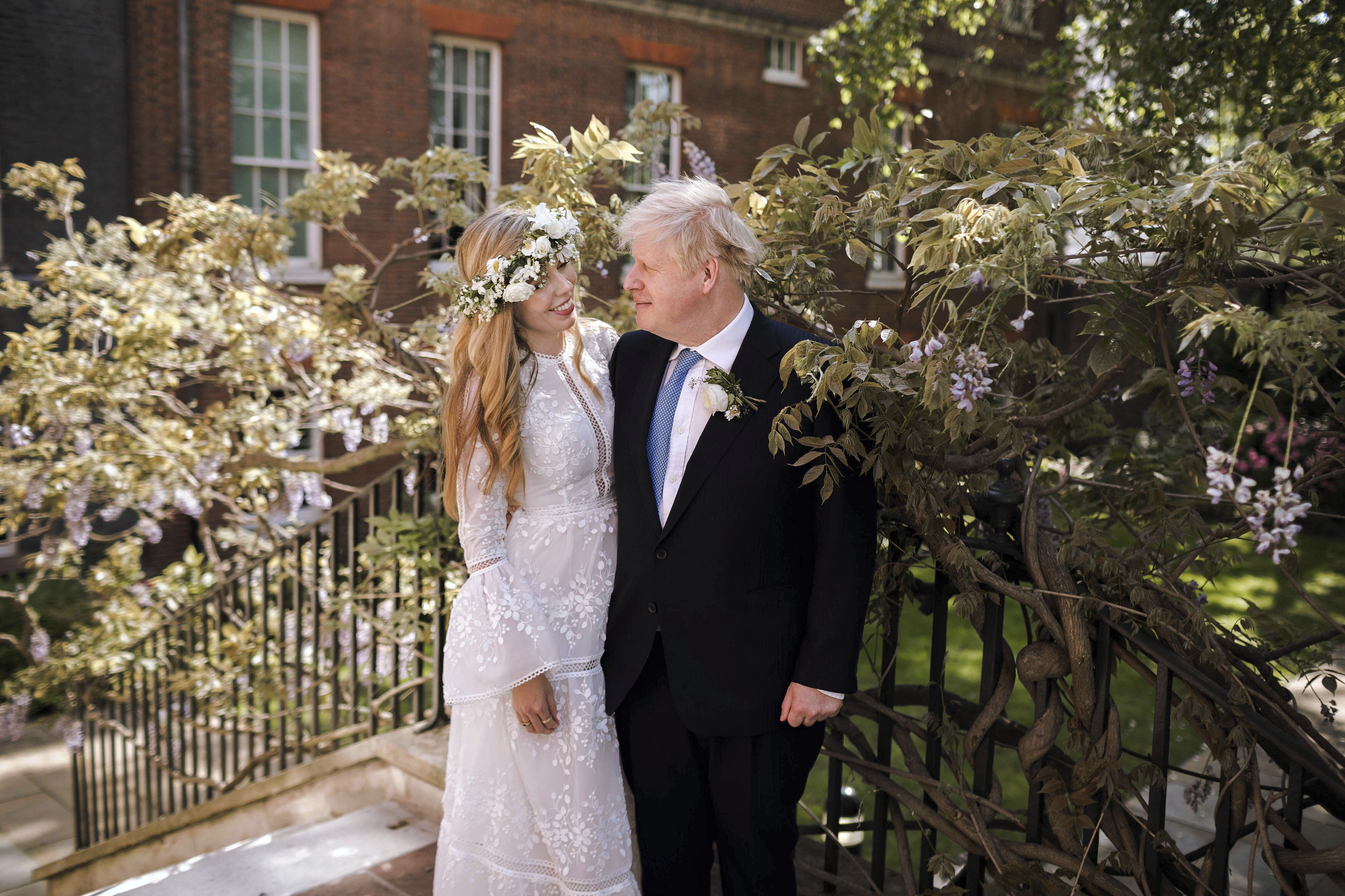 In this image released Sunday, May 30, 2021, by Downing Street, Britain's Prime Minister Boris Johnson and Carrie Johnson pose together for a photo in the garden of 10 Downing Street after their wedding on Saturday. Boris Johnson and his fiancée Carrie Symonds are newlyweds, according to an announcement from his Downing Street office saying they were married Saturday in a small private ceremony in London. (Rebecca Fulton/Downing Street via AP) 
