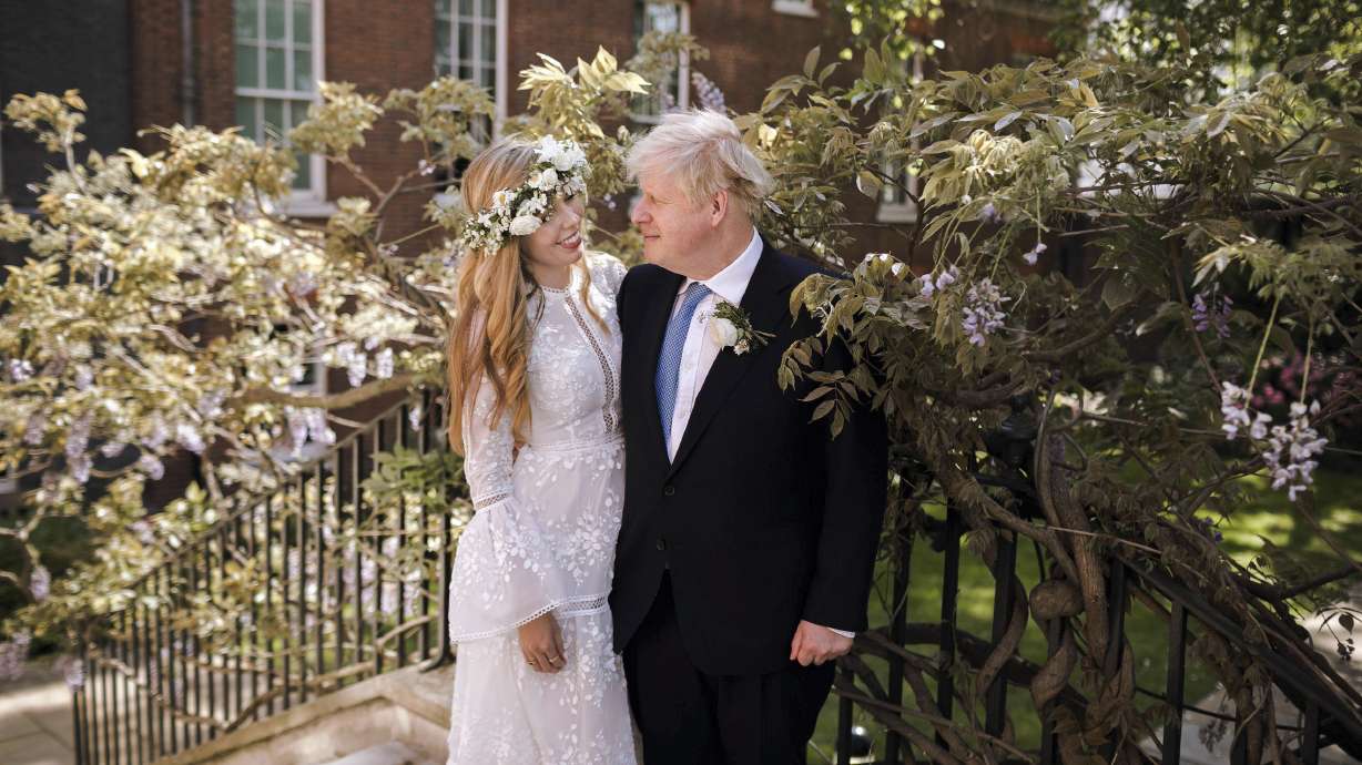 In this image released Sunday, May 30, 2021, by Downing Street, Britain's Prime Minister Boris Johnson and Carrie Johnson pose together for a photo in the garden of 10 Downing Street after their wedding on Saturday. Boris Johnson and his fiancée Carrie Symonds are newlyweds, according to an announcement from his Downing Street office saying they were married Saturday in a small private ceremony in London. (Rebecca Fulton/Downing Street via AP)