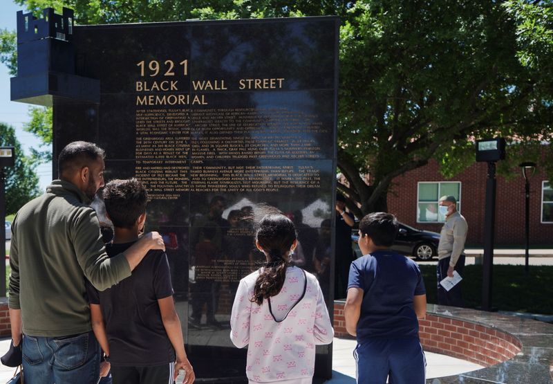 FILE PHOTO: A family reads the Black Wall Street Memorial during festivities of the 100 year anniversary of the 1921 Tulsa Massacre in Tulsa, Oklahoma, U.S., May 29, 2021. REUTERS/Lawrence Bryant