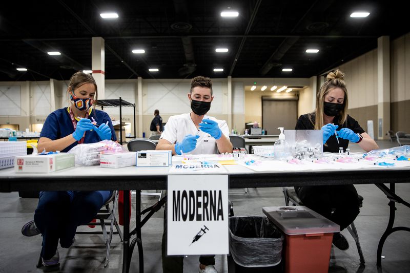 Nurse apprentice Ramie Best, left, lead nurse Seth
Christensen and nurse Jessica Hack fill syringes with doses of the
Moderna COVID-19 vaccine at the Mountain America Expo Center in
Sandy on Thursday, April 22, 2021.