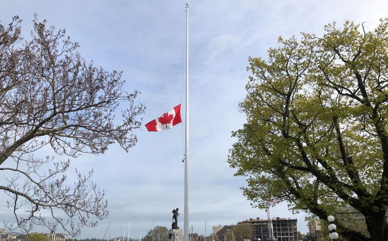 FILE PHOTO: Canada's national flag flies at half-mast at the British Columbia Legislature in Victoria, after the remains of 215 children were discovered in a mass grave at the former Kamloops Indian Residential School site, May 30, 2021. Legislative Assembly of BC/Handout via REUTERS