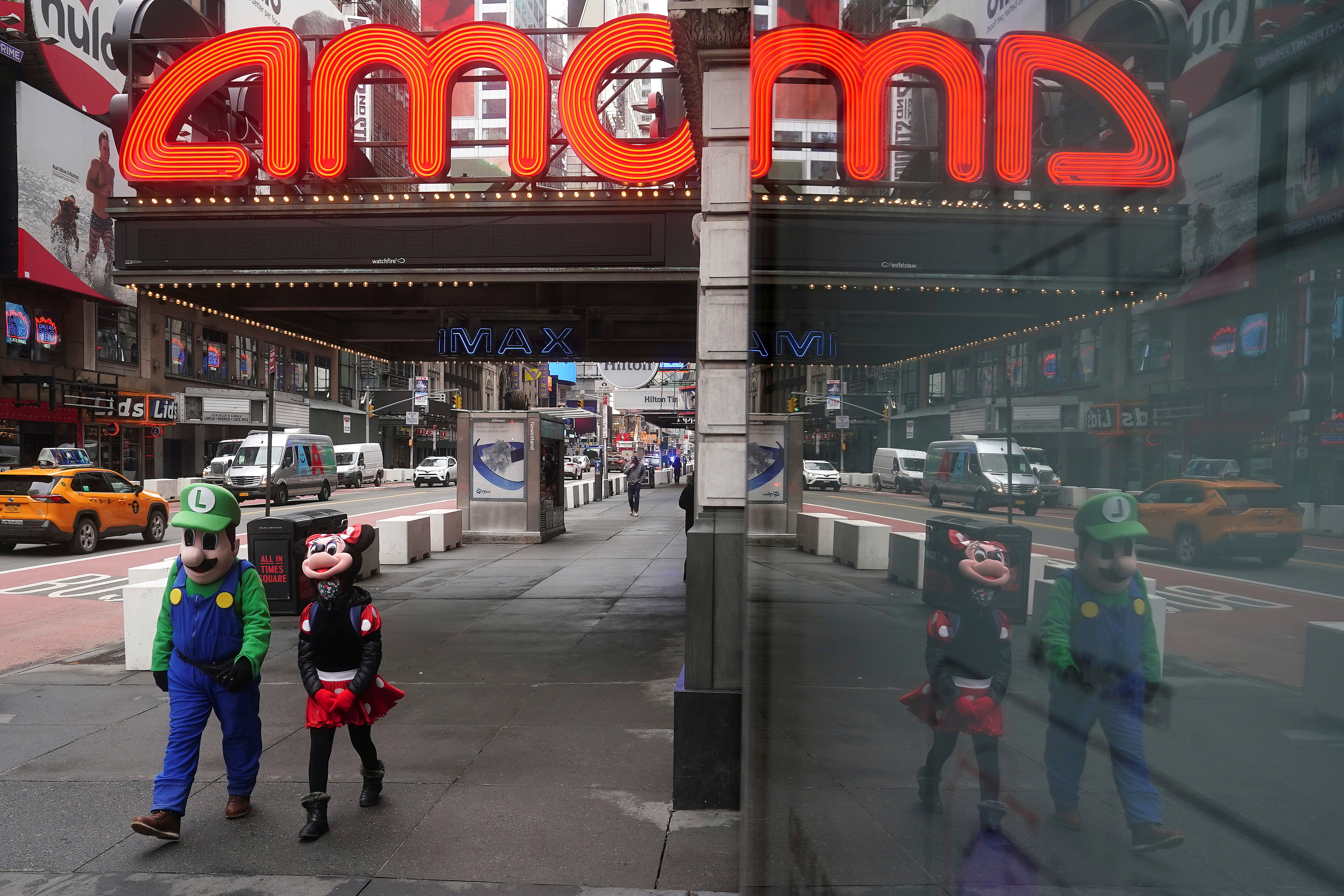 FILE PHOTO: Times Square characters who pose for photos for money walk past an AMC theatre amid the coronavirus disease (COVID-19) pandemic in the Manhattan borough of New York City, New York, U.S., Jan. 27, 2021. REUTERS/Carlo Allegri