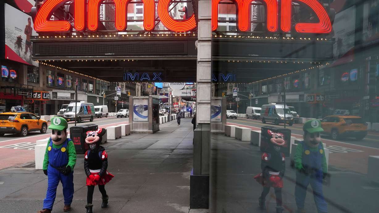 FILE PHOTO: Times Square characters who pose for photos for money walk past an AMC theatre amid the coronavirus disease (COVID-19) pandemic in the Manhattan borough of New York City, New York, U.S., Jan. 27, 2021. REUTERS/Carlo Allegri