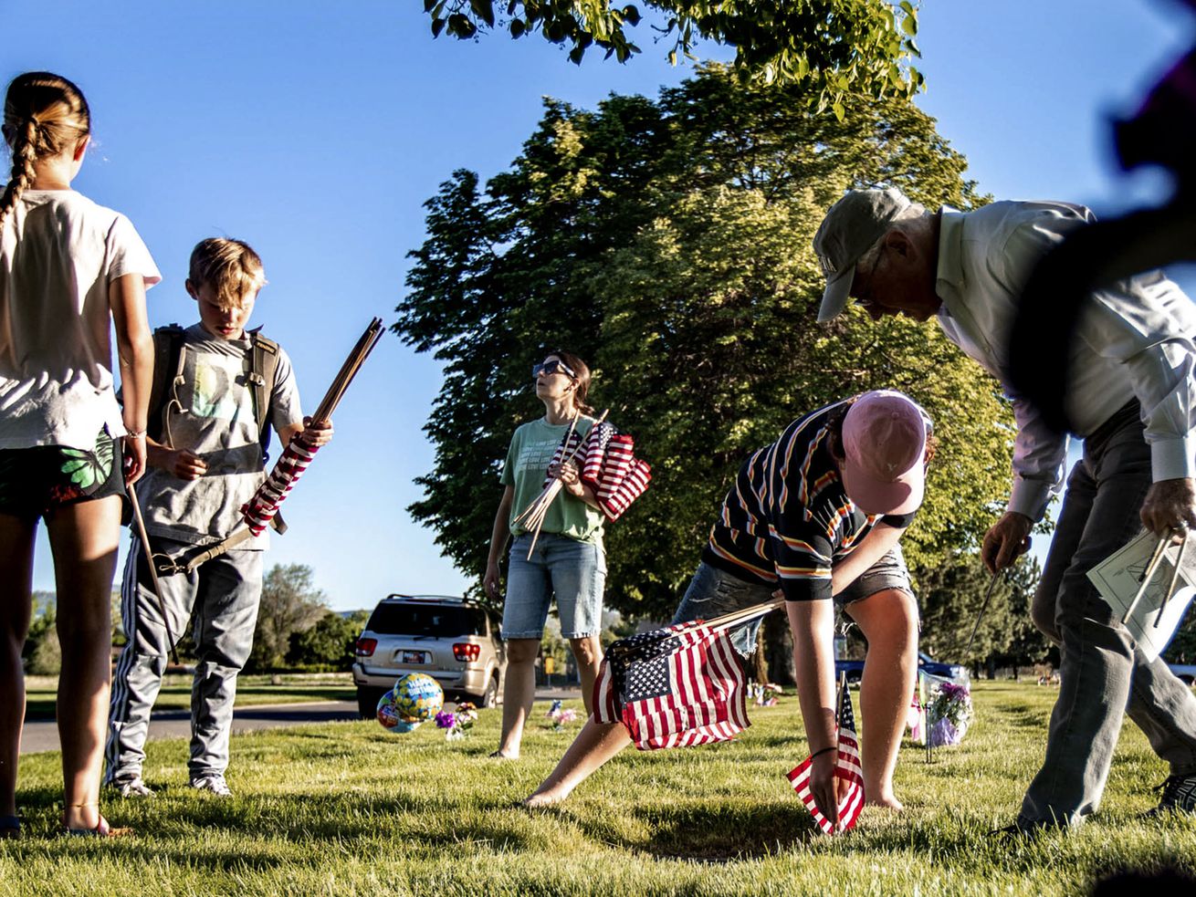 Volunteers place flags at Larkin Sunset Gardens
Cemetery in Sandy on Thursday, May 27, 2021. Utah isn’t expecting a
significant spike in COVID-19 cases from last weekend’s Memorial
Day gatherings that marked the start of a summer with fewer virus
restrictions, unlike what the state and the rest of the country
experienced after past holiday celebrations.