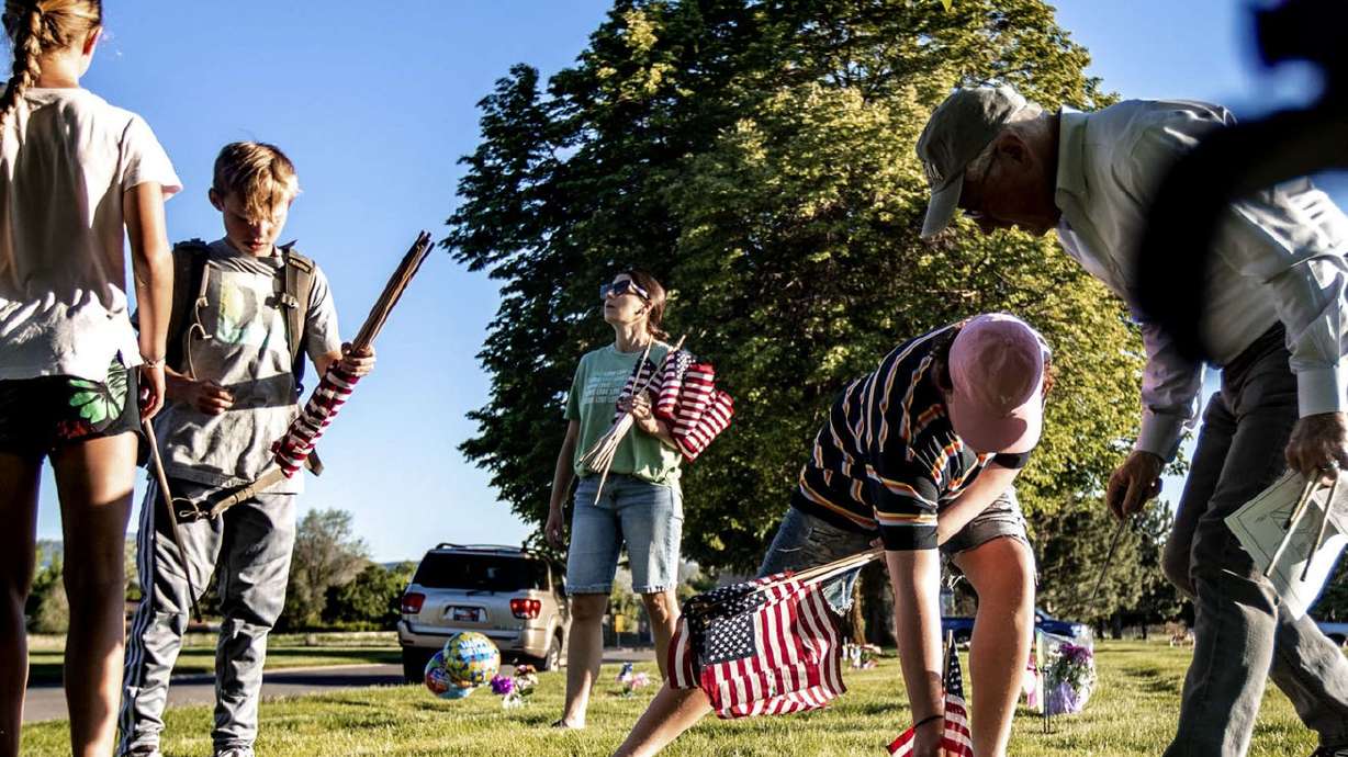 Volunteers place flags at Larkin Sunset Gardens
Cemetery in Sandy on Thursday, May 27, 2021. Utah isn’t expecting a
significant spike in COVID-19 cases from last weekend’s Memorial
Day gatherings that marked the start of a summer with fewer virus
restrictions, unlike what the state and the rest of the country
experienced after past holiday celebrations.