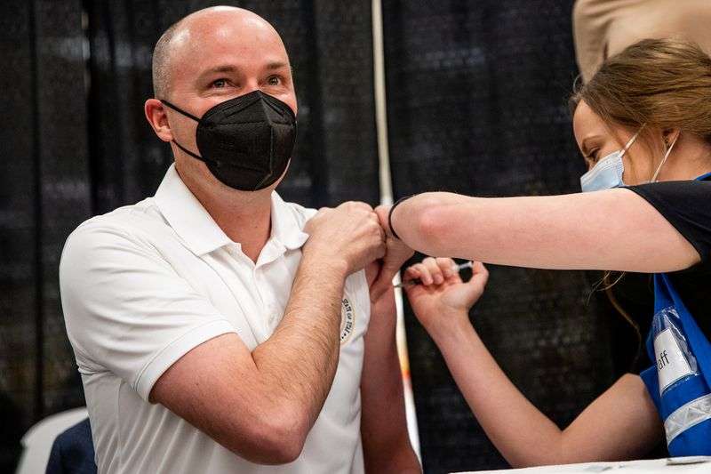Gov. Spencer Cox, left, receives his first dose of the Pfizer-BioNTech COVID-19 vaccine at a vaccination site run by the Utah County Health Department in Spanish Fork on March 25, 2021.