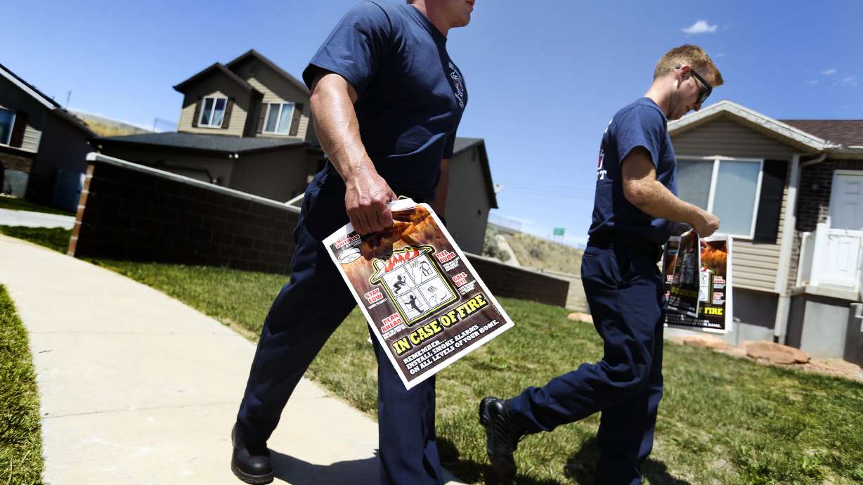 Salt Lake City fire fighters Derek Mickelson and Dylan Hansen deliver Ready, Set, Go! wildland fire action guides to resents on the westside of Salt Lake City on Saturday, June 5, 2021. The Ready, Set, Go! program seeks to share information with residents on how they can successfully become prepared in the event of a wildland fire.