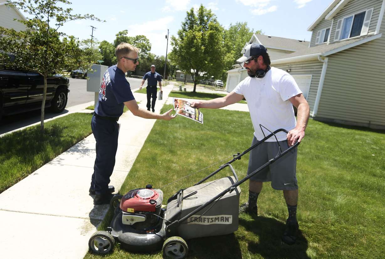 Salt Lake City fire fighter Dylan Hansen gives Marc Blackhurst a Ready, Set, Go! wildland fire action guide in Salt Lake City on Saturday, June 5, 2021. The program seeks to share information with residents on how they can successfully become prepared in the event of a wildland fire.