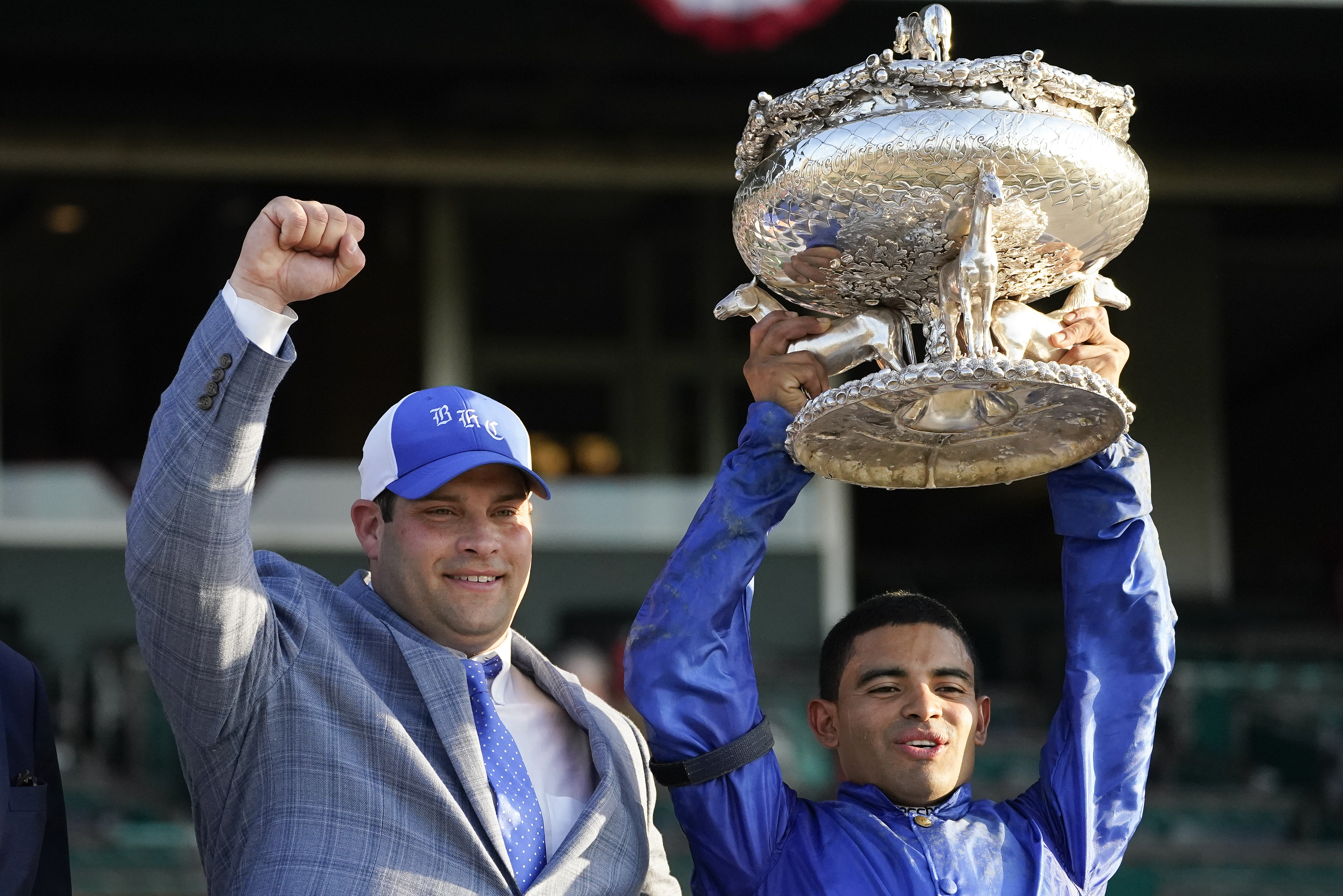 Trainer Brad Cox, left, and jockey Luis Saez pose for a photo with the August Belmont Trophy after winning the 153rd running of the Belmont Stakes horse race with Essential Quality (2), Saturday, June 5, 2021, at Belmont Park in Elmont, N.Y.