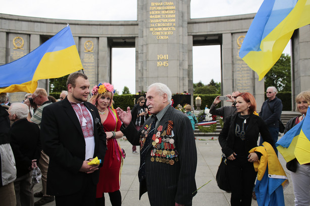 FILE - In this Friday, May 8, 2015 file photo, Soviet war veteran David Dushman, 92, center, speaks to people holding Ukrainian flags as he attends a wreath laying ceremony at the Russian War Memorial in the Tiergarten district of Berlin, Germany. Dushman, the last surviving Allied soldier involved in the liberation of Auschwitz, has died. The Jewish Community of Munich and Upper Bavaria said Sunday, June 6, 2021 that Dushman had died a day earlier in a Munich hospital at the age of 98. As young Red Army soldier, Dushman flattened the forbidding fence around the notorious Nazi death camp with his tank on Jan. 27, 1945.