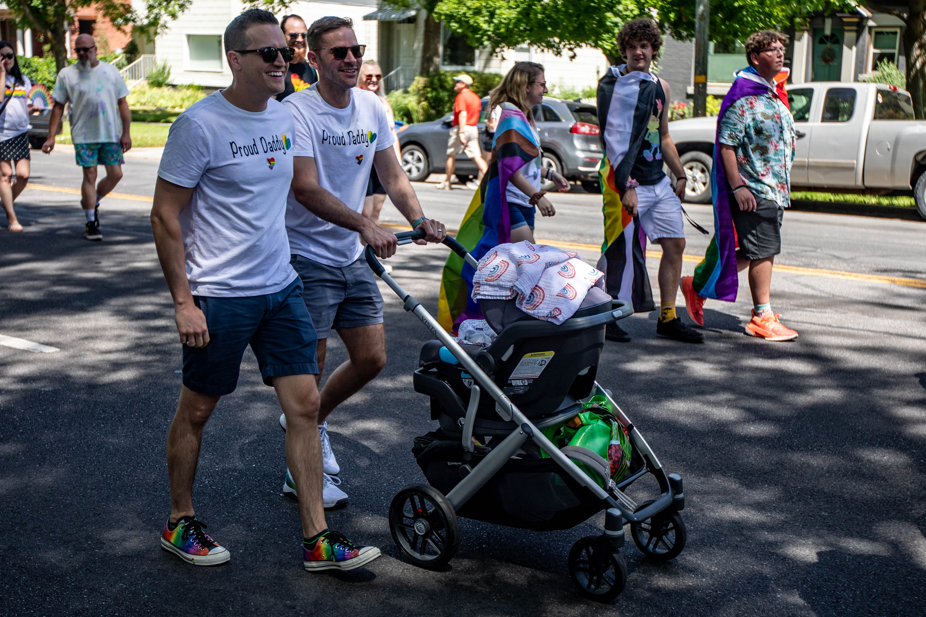 Two fathers walk with their child during the Rainbow March along State Street and 900 South headed to Liberty Park in Salt Lake City on Sunday, June 6, 2021.