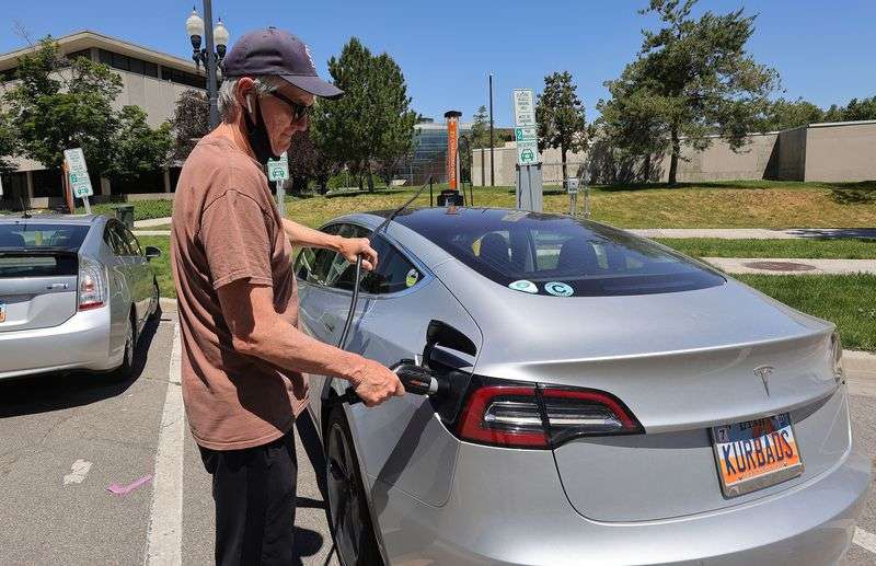 David Mack charges his electric vehicle in Salt Lake
City on Friday, June 4, 2021. Disruptions to production of
semiconductor chips have led to inventory shortages and record
prices for new electric cars.