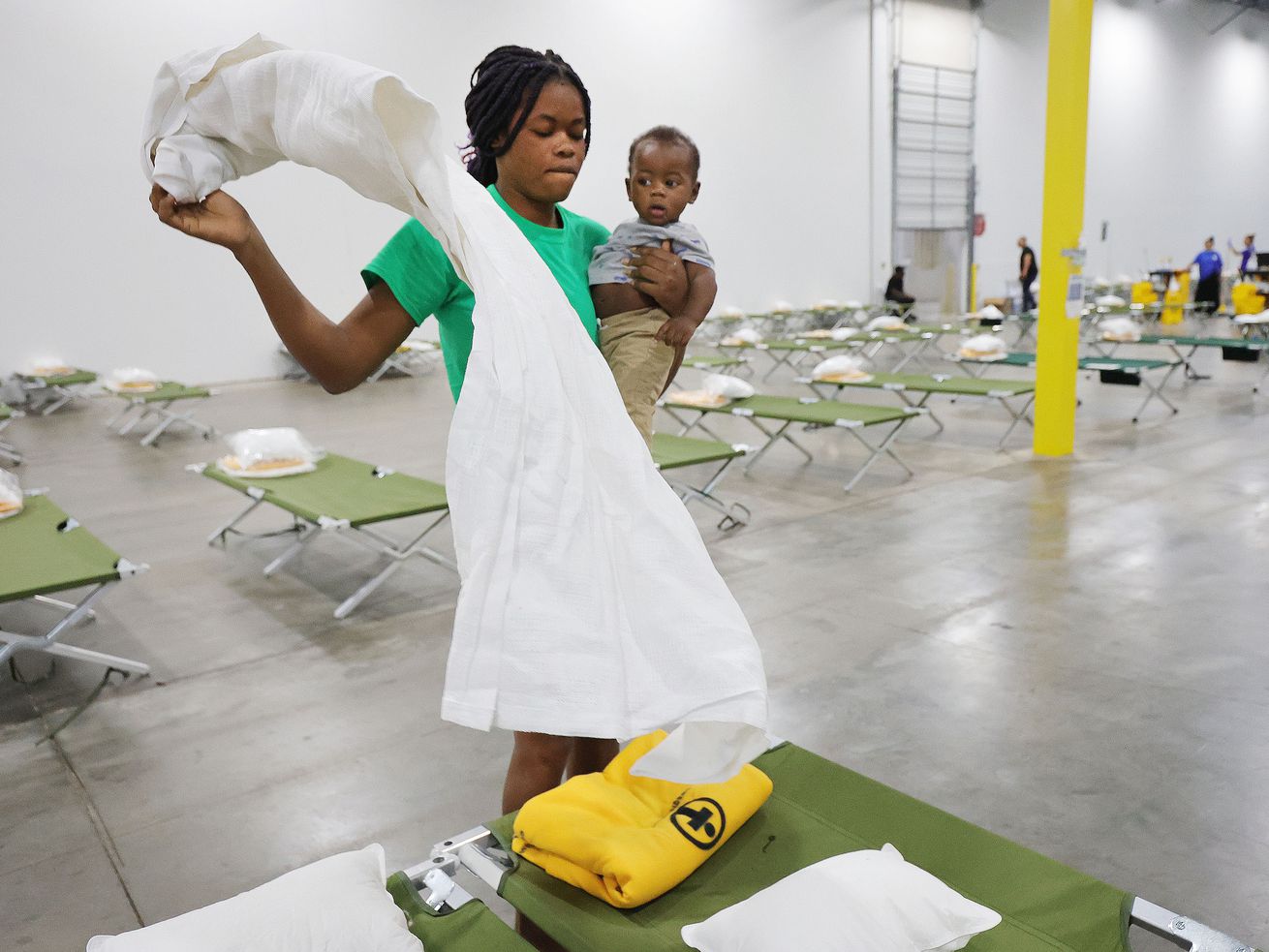 Refugee Jouseline Melayer, form Chile, holds her baby Jayden as she folds bed linens at the Family Transfer Center in Houston on Monday, June 7, 2021. The Center provides a temporary respite for families who have been cleared at the United States border and need short-term shelter and food. The creation of the Family Transfer Center is the result of a collaboration between The Church of Jesus Christ of Latter-day Saints, Catholic Charities, The National Association of Christian Churches, YMCA International Services, Texas Adventist Community Services, Houston Responds, and The Houston Foodbank.