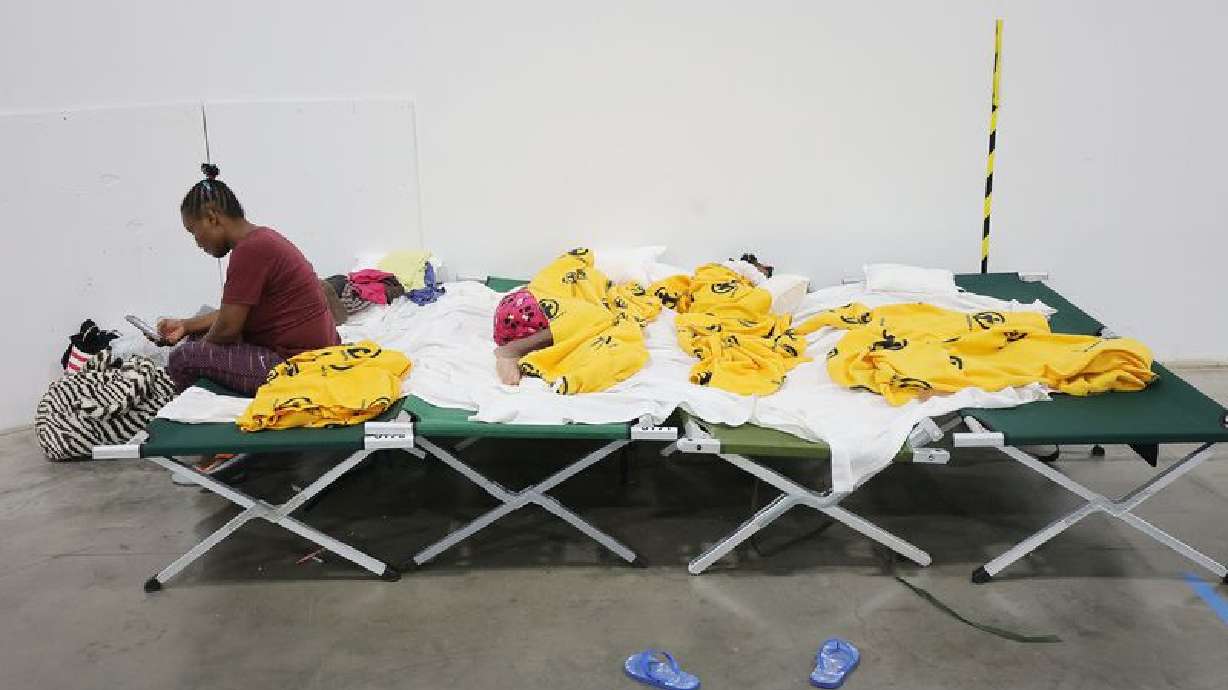 Refugee France Naolege, from Brazil, sits on her bunk as her children sleep at the Family Transfer Center in Houston on Monday, June 7, 2021.