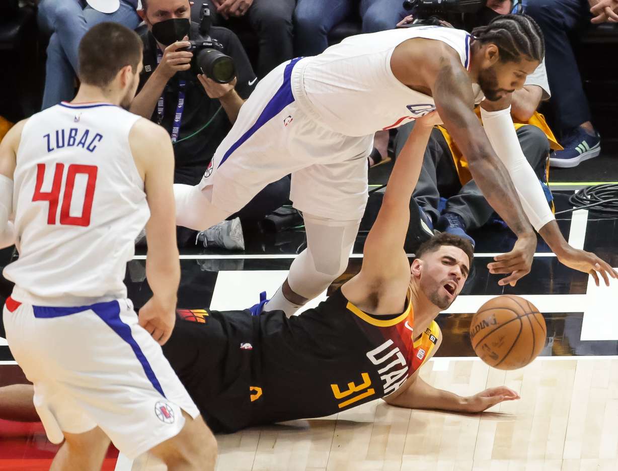LA Clippers guard Paul George (13) and Utah Jazz forward Georges Niang (31) dive for the ball during Game 1 of the Western Conference semifinals at Vivint Smart Home Arena in Salt Lake City on Tuesday, June 8, 2021.