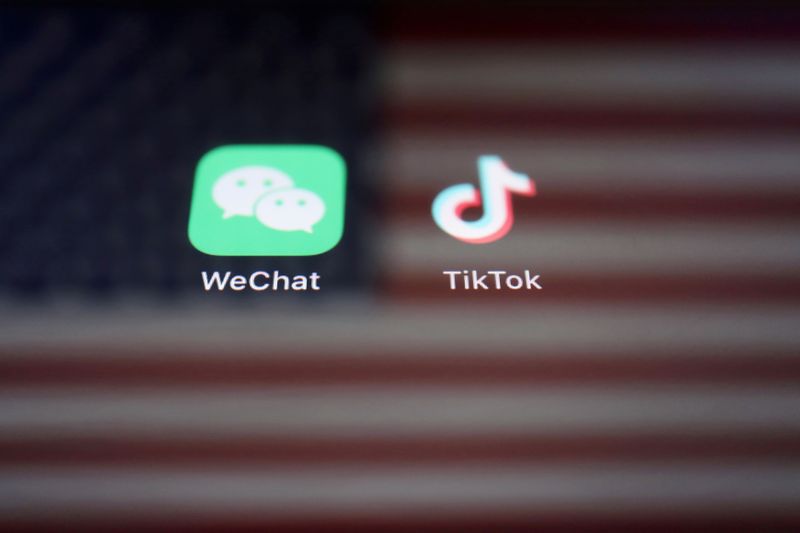 FILE PHOTO: A reflection of the U.S. flag is seen on the signs of the WeChat and TikTok apps in this illustration picture taken Sept. 19, 2020.  