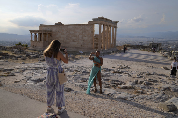 FILE - In this Tuesday, June 8, 2021 file photo, a tourist take photos at the Parthenon temple during a media tour for the Foreign Correspondents organised by the Greek Cultural Ministry at the Acropolis hill in Athens.