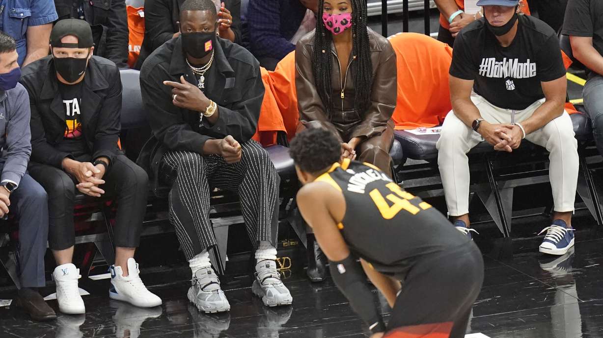 Utah Jazz owner Dwyane Wade speaks with Donovan Mitchell during the second half of Game 1 of a second-round NBA basketball playoff series against the LA Clippers.