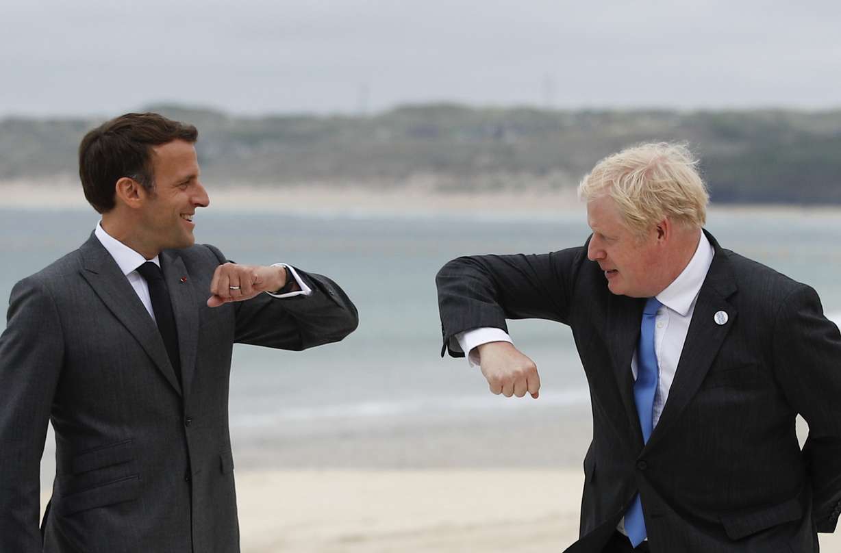 British Prime Minister Boris Johnson, right, greets French President Emmanuel Macron during arrivals for the G7 meeting at the Carbis Bay Hotel in Carbis Bay, St. Ives, Cornwall, England, Friday, June 11, 2021.