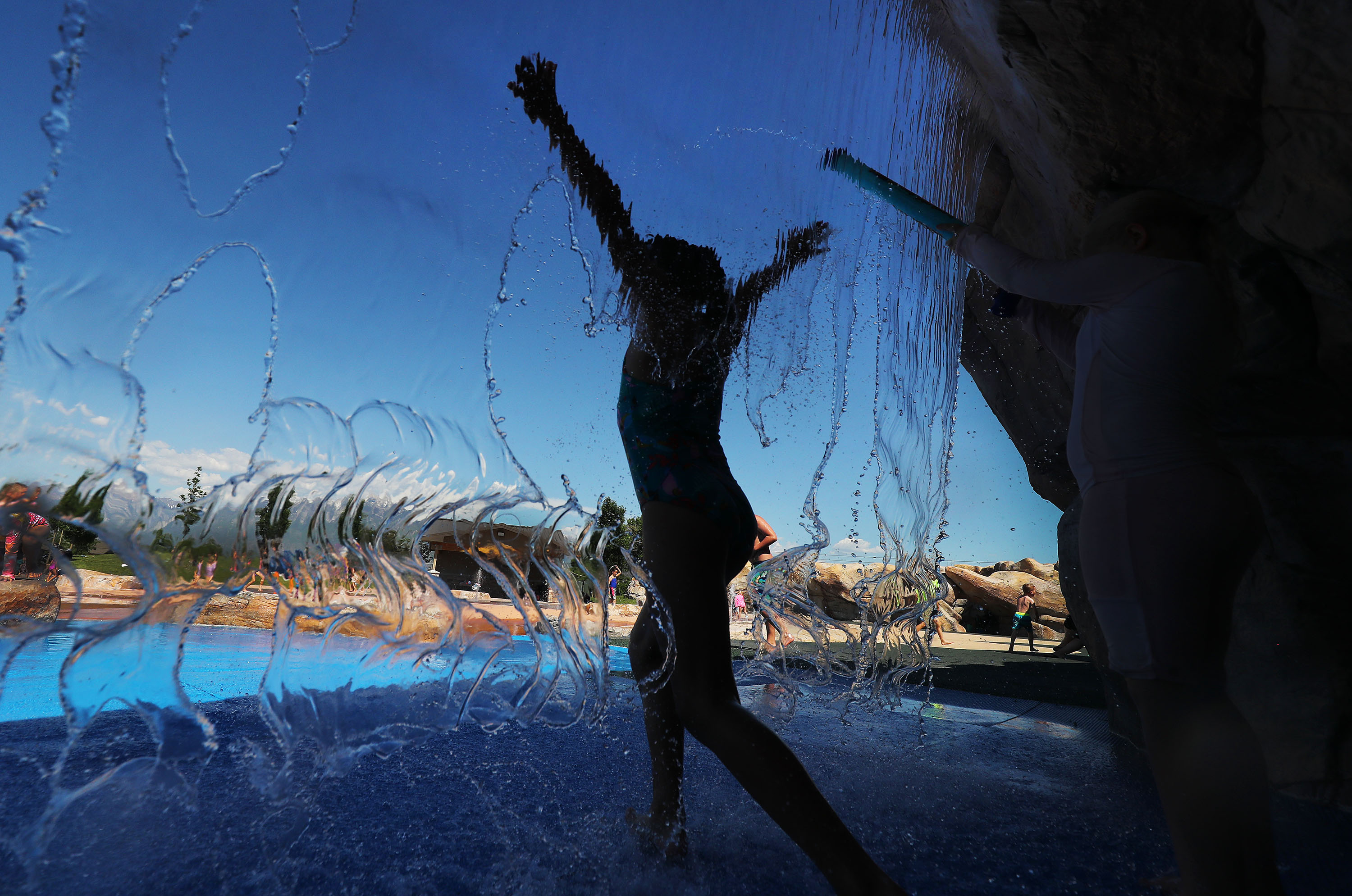 Children cool off in the water at Wardle Fields Regional Park splash pad in Bluffdale on Thursday, June 3, 2021.