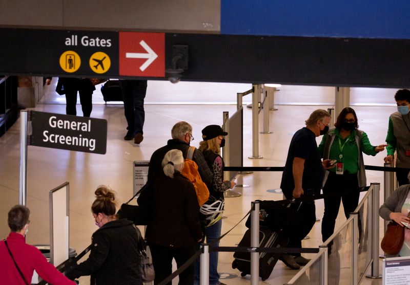 FILE PHOTO: Travelers go through general screening at a security checkpoint at Seattle-Tacoma International Airport in SeaTac, Washington, U.S. April 12, 2021.  REUTERS/Lindsey Wasson