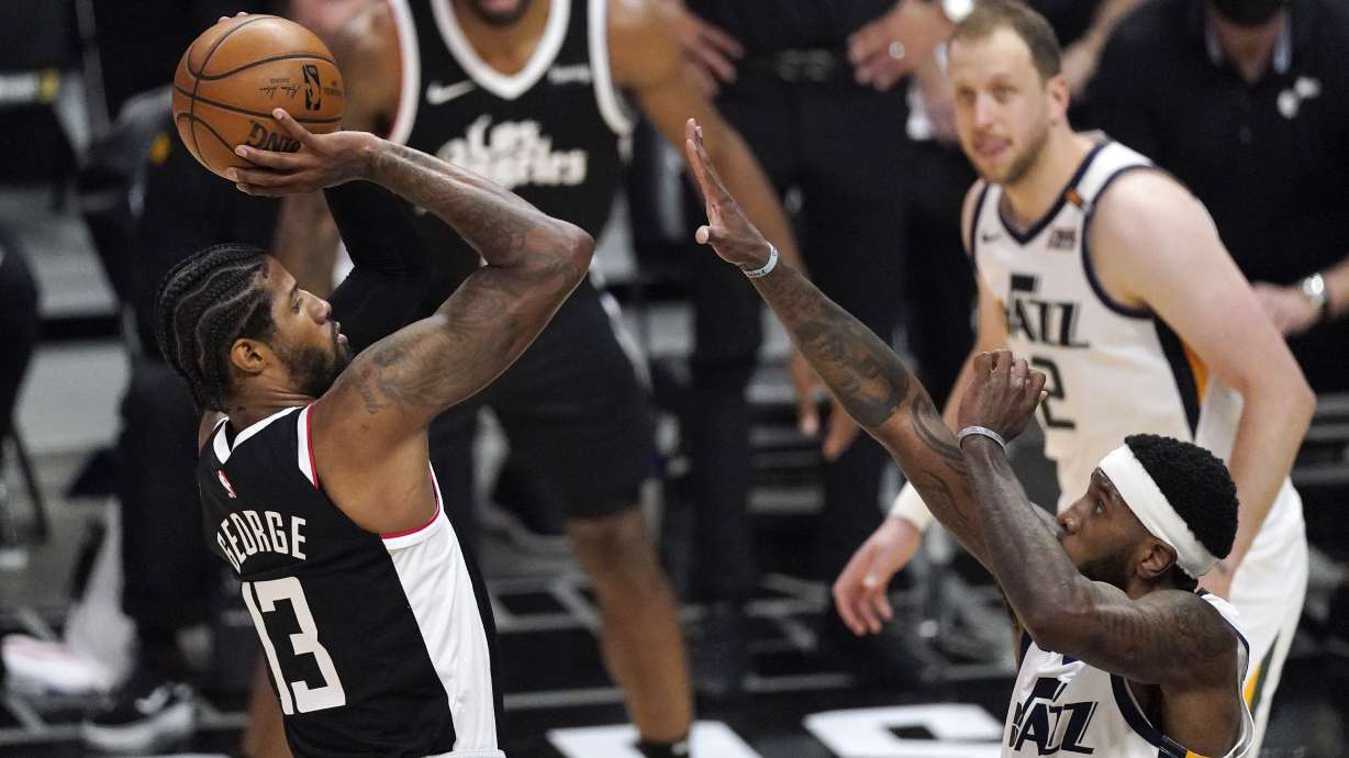 Los Angeles Clippers guard Paul George, left, shoots as Utah Jazz forward Royce O'Neale defends during the second half of Game 3 of a second-round NBA basketball playoff series Saturday, June 12, 2021, in Los Angeles.