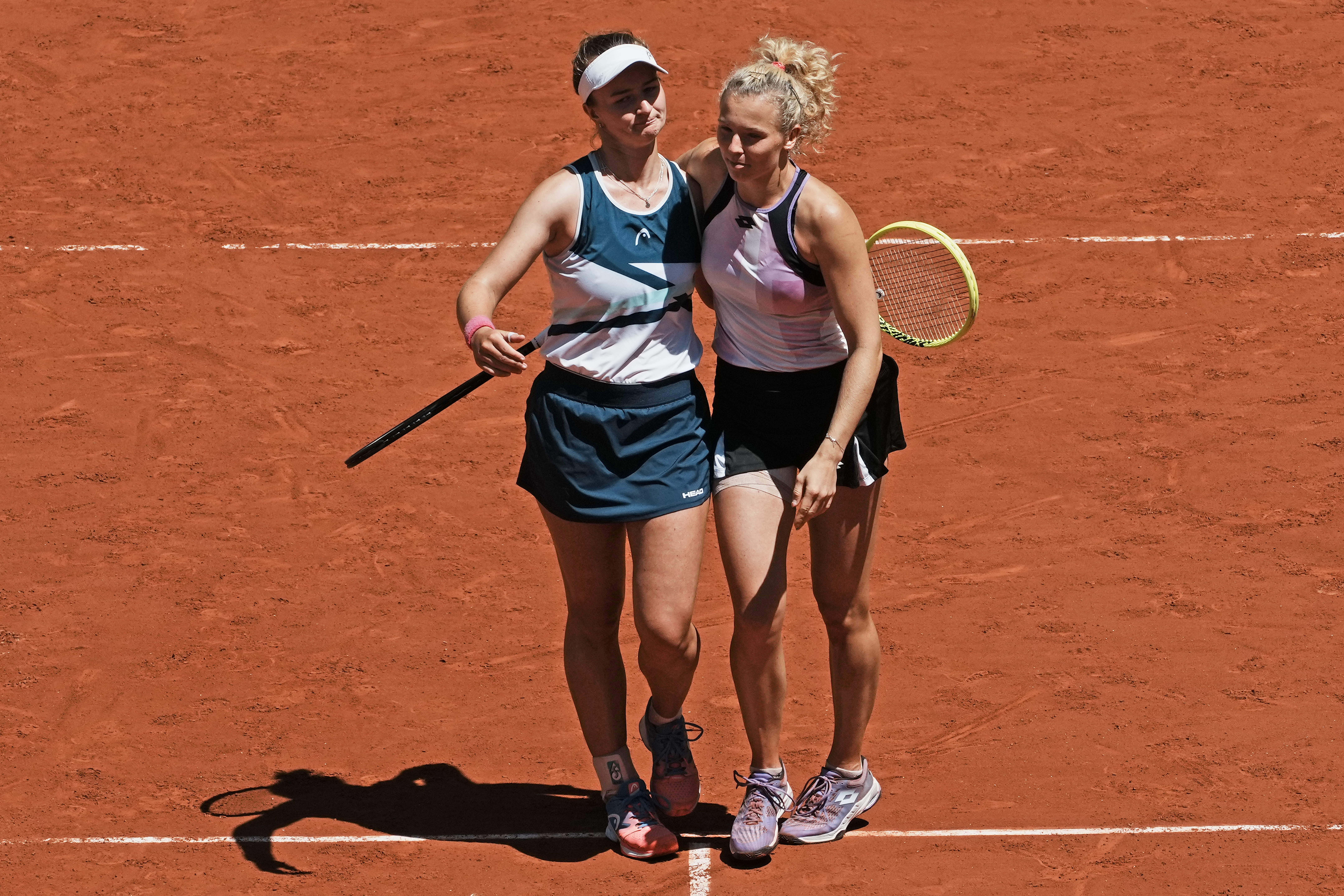 Czech Republic's Barbora Krejcikova, left, and compatriot Katerina Siniakova walk together after defeating USA's Bethanie Mattek-Sands and Poland's Iga Swiatek during their women's doubles final match of the French Open tennis tournament at the Roland Garros stadium Sunday, June 13, 2021 in Paris.