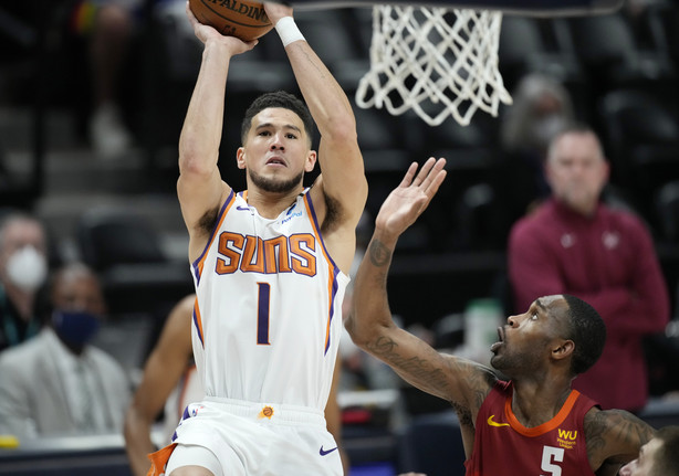 Phoenix Suns guard Devin Booker, left, goes up for a basket as Denver Nuggets forward Will Barton defends in the first half of Game 4 of an NBA second-round playoff series Sunday, June 13, 2021, in Denver.
