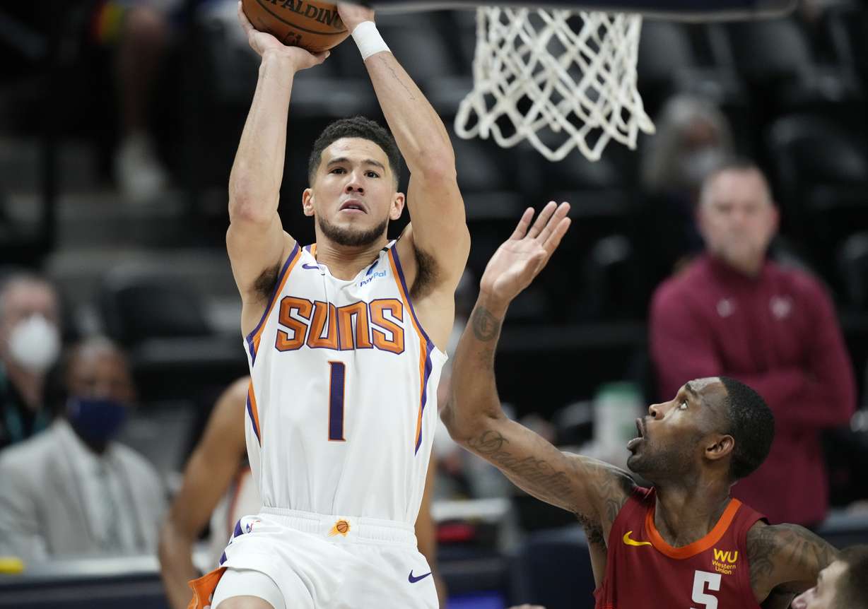 Phoenix Suns guard Devin Booker, left, goes up for a basket as Denver Nuggets forward Will Barton defends in the first half of Game 4 of an NBA second-round playoff series Sunday, June 13, 2021, in Denver.