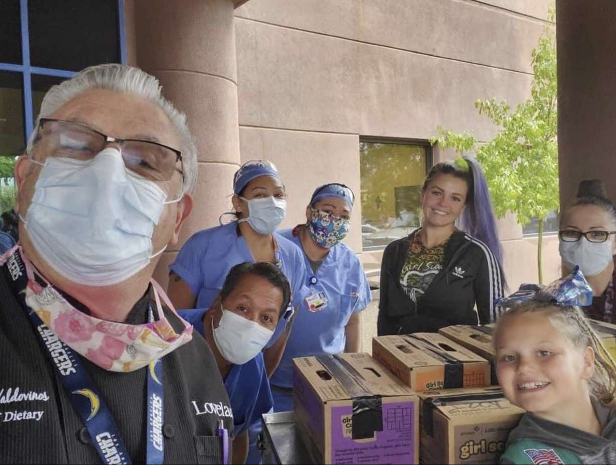 This undated photo provided by Girl Scouts of New Mexico Trails shows Henrique Valdovinos, left, and other health care workers at the Lovelace Women's Hospital in Albuquerque, New Mexico, receiving a donation of cookies as part of the Girl Scouts' Hometown Heroes program. (Girl Scouts of New Mexico Trails via AP)
