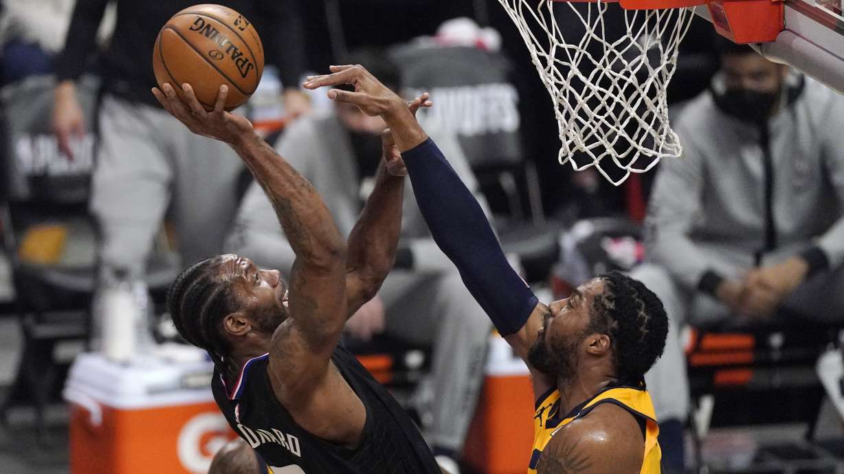 Los Angeles Clippers forward Kawhi Leonard, left, shoots as Utah Jazz center Derrick Favors defends during the first half in Game 4 of a second-round NBA basketball playoff series Monday, June 14, 2021, in Los Angeles.