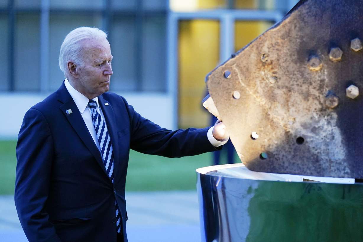 President Joe Biden touches a piece of steel from the North Tower of the World Trade Center while visiting a memorial to the September 11 terrorist attacks at NATO headquarters in Brussels, Monday, June 14, 2021.